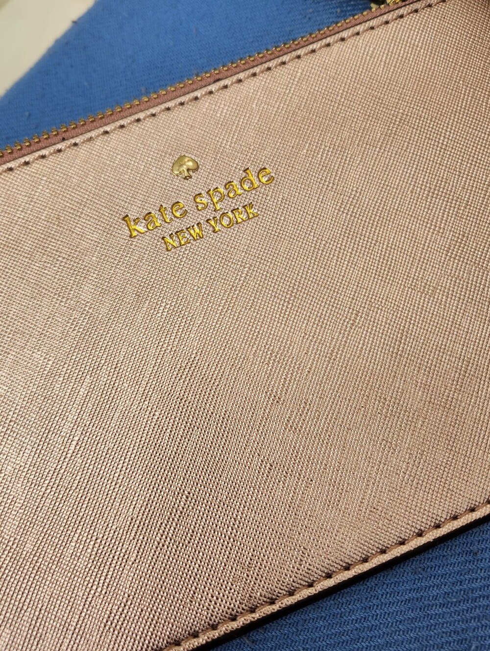 kate spade metallic rosegold wristlet with gold logo